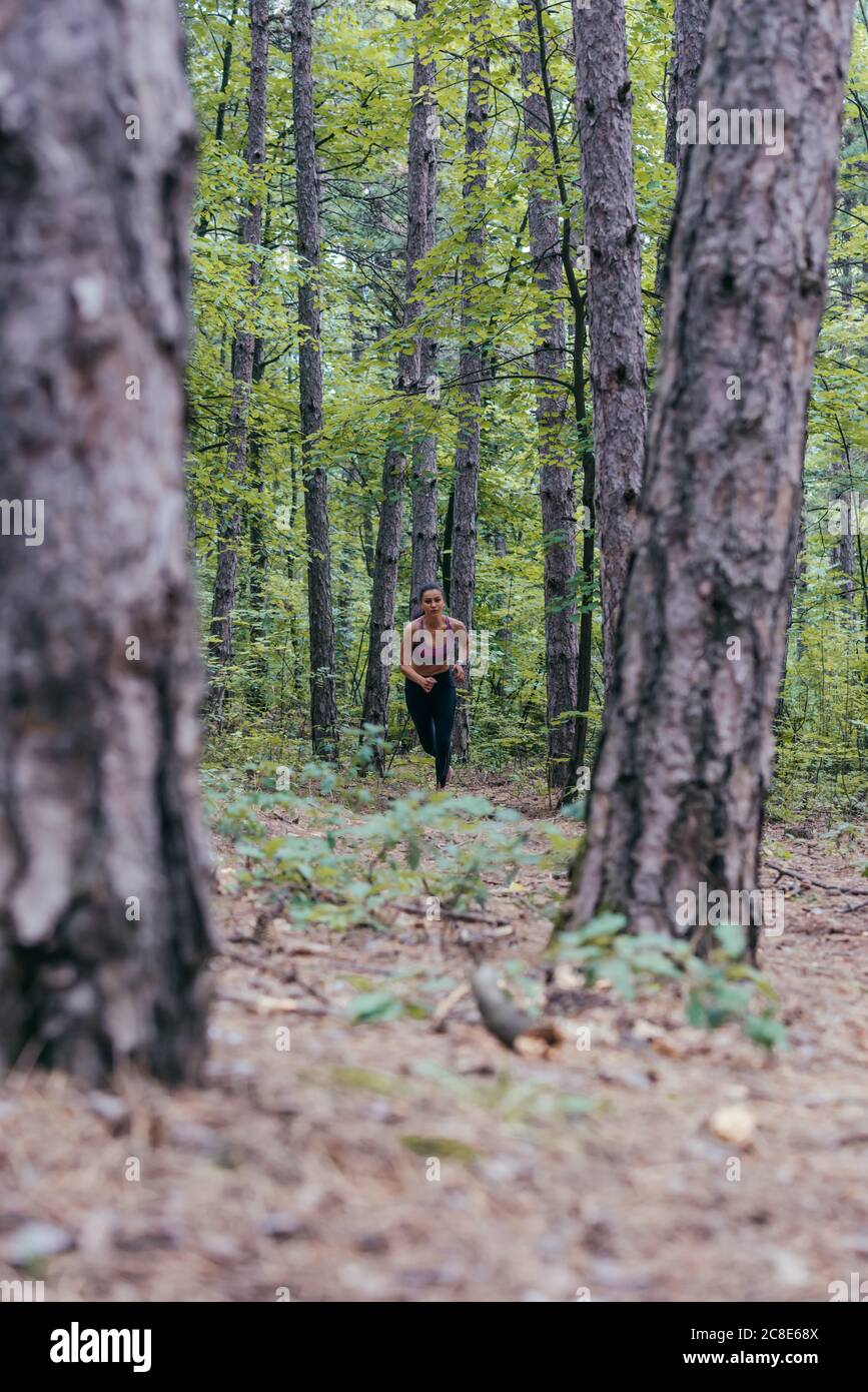 Giovane caucasica ragazza jogging nella foresta visto da lontano. Foto Stock