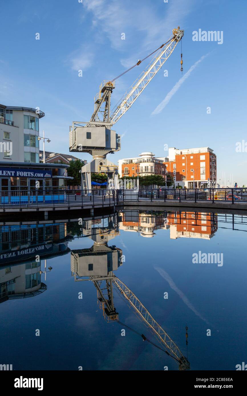 Una vecchia gru portuale che riflette in acqua a Gunwharf Quays Portsmouth Foto Stock
