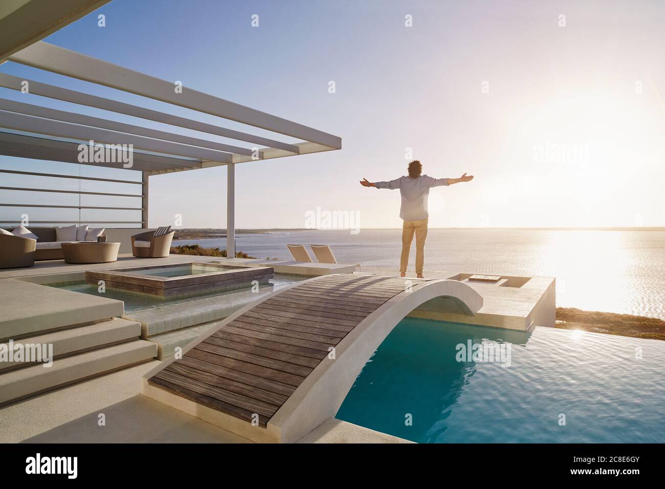 Uomo in piedi sul ponte sopra una piscina godendo il visualizza Foto Stock