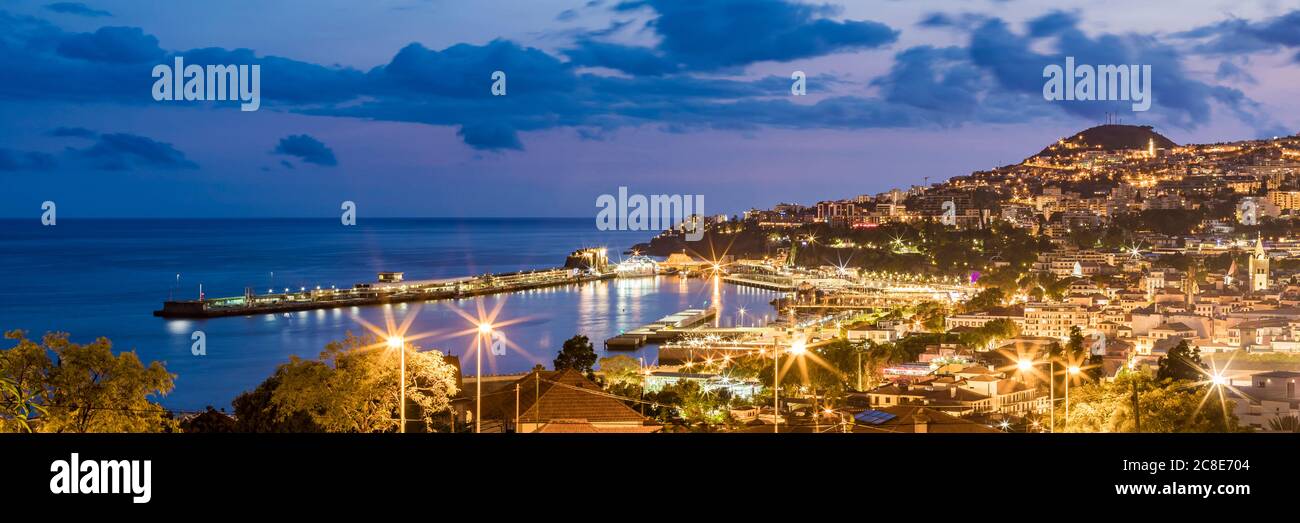 Portogallo, Funchal, Panorama della città costiera illuminata al tramonto Foto Stock