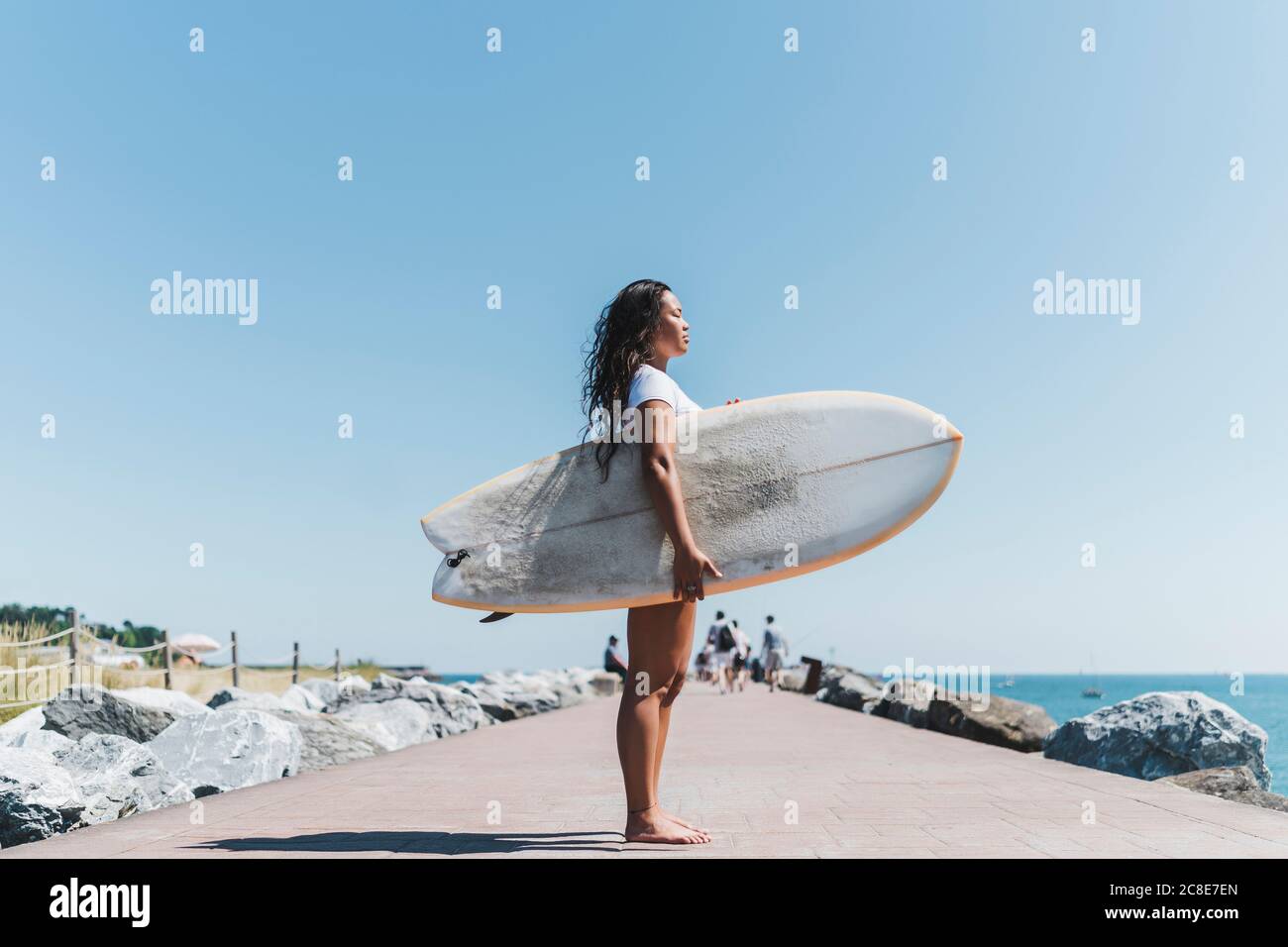 Surfista femminile con tavola da surf all'aperto Foto Stock