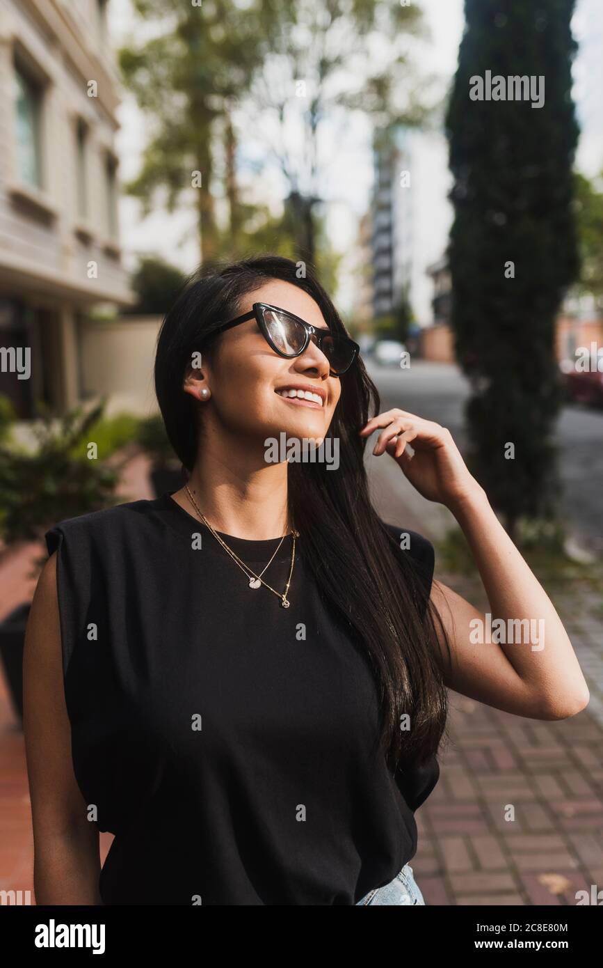 Donna con occhiali da sole in città Foto Stock