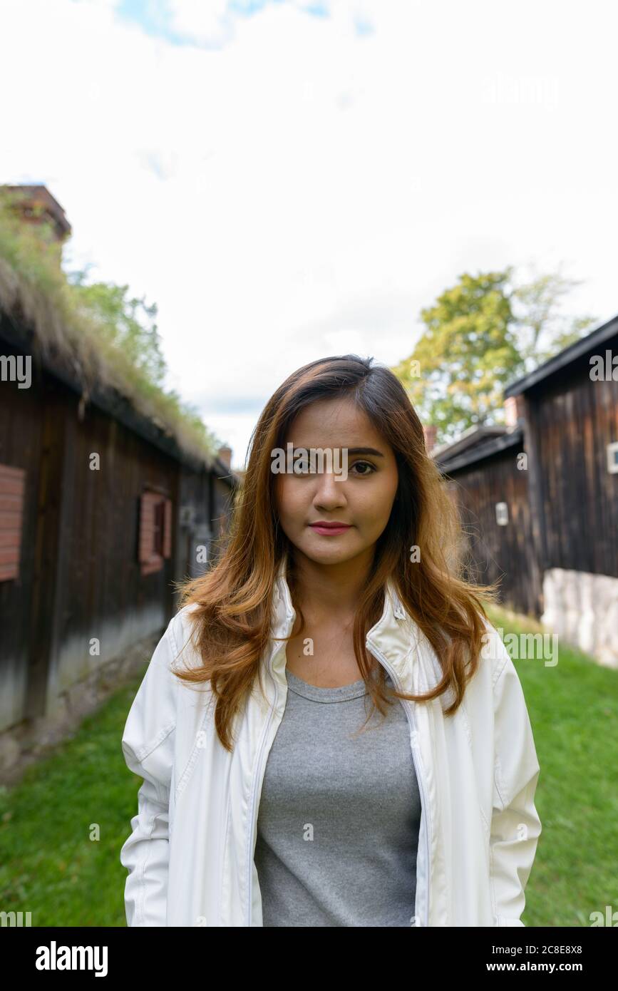 Giovane bella donna asiatica nel mezzo di vecchie case di legno allineate Foto Stock