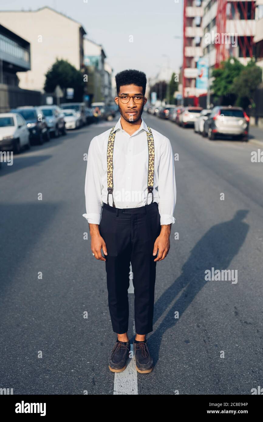 Ritratto di un giovane giovane sicuro ed elegante in piedi sul via in città Foto Stock