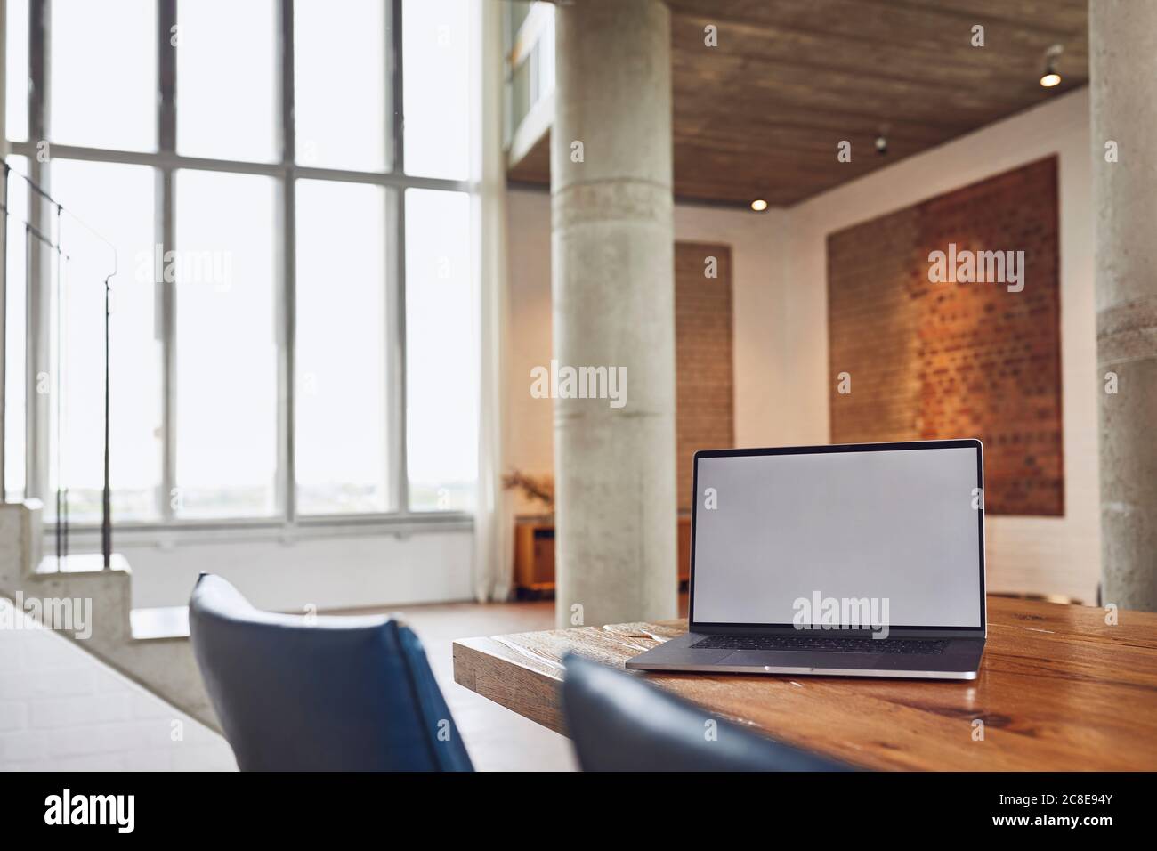 Computer portatile su tavolo di legno in un loft appartamento Foto Stock