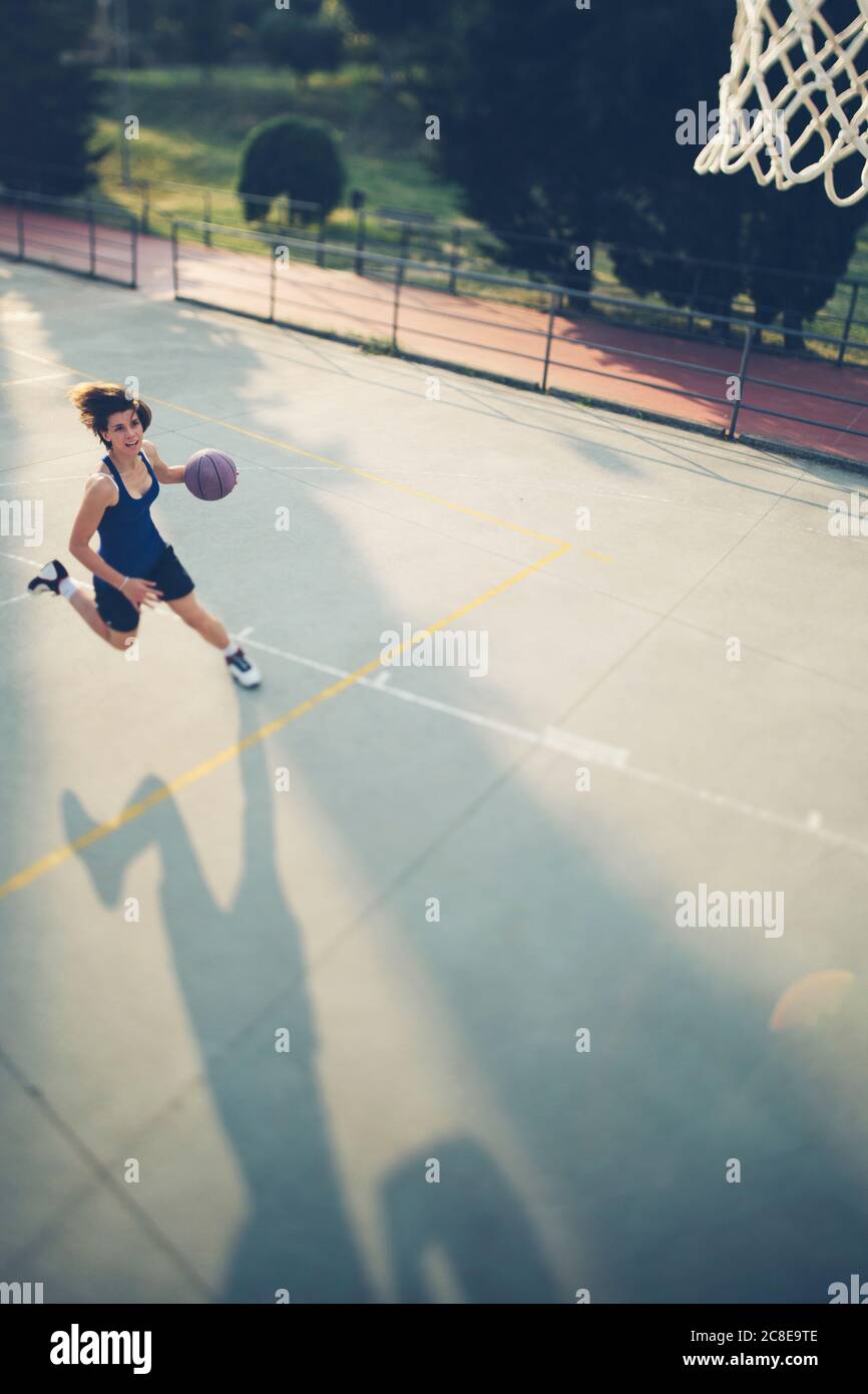 Atleta che corre con il basket mentre si pratica sul campo Foto Stock