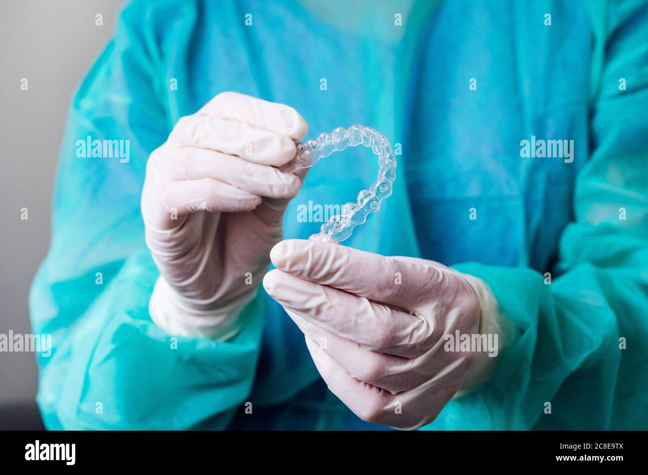 Primo piano di dentista che tiene gli allineatori dentali nella forma del cuore a. clinica Foto Stock