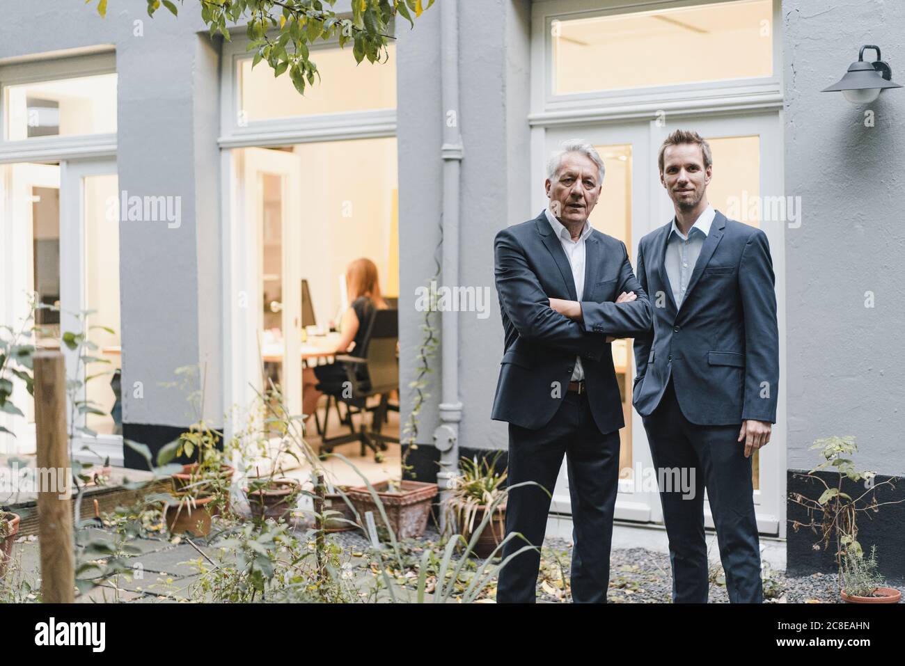 Due uomini d'affari di successo in piedi sul cortile del loro ufficio Foto Stock