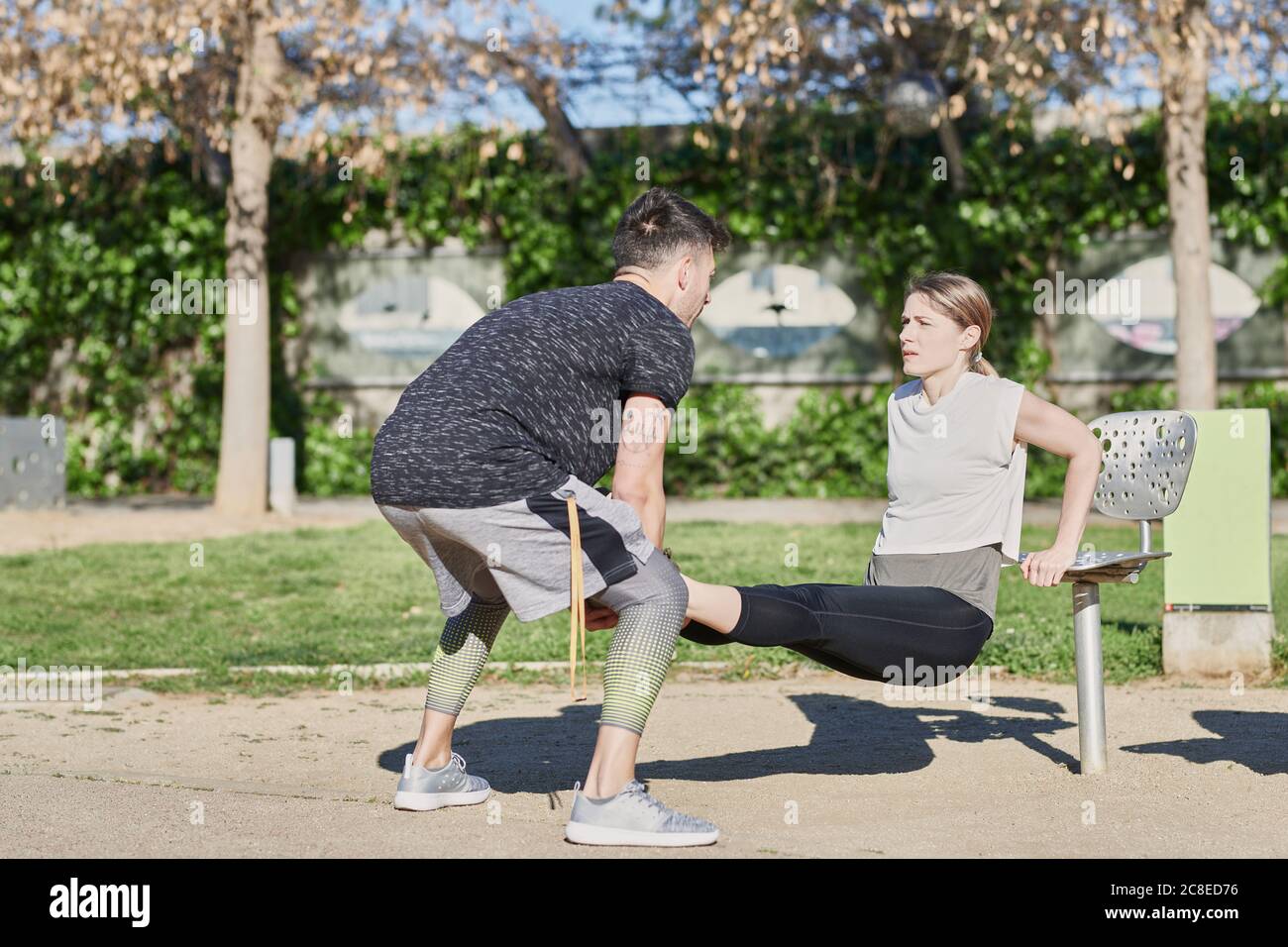 Donna durante il lavoro con allenatore nel parco Foto Stock