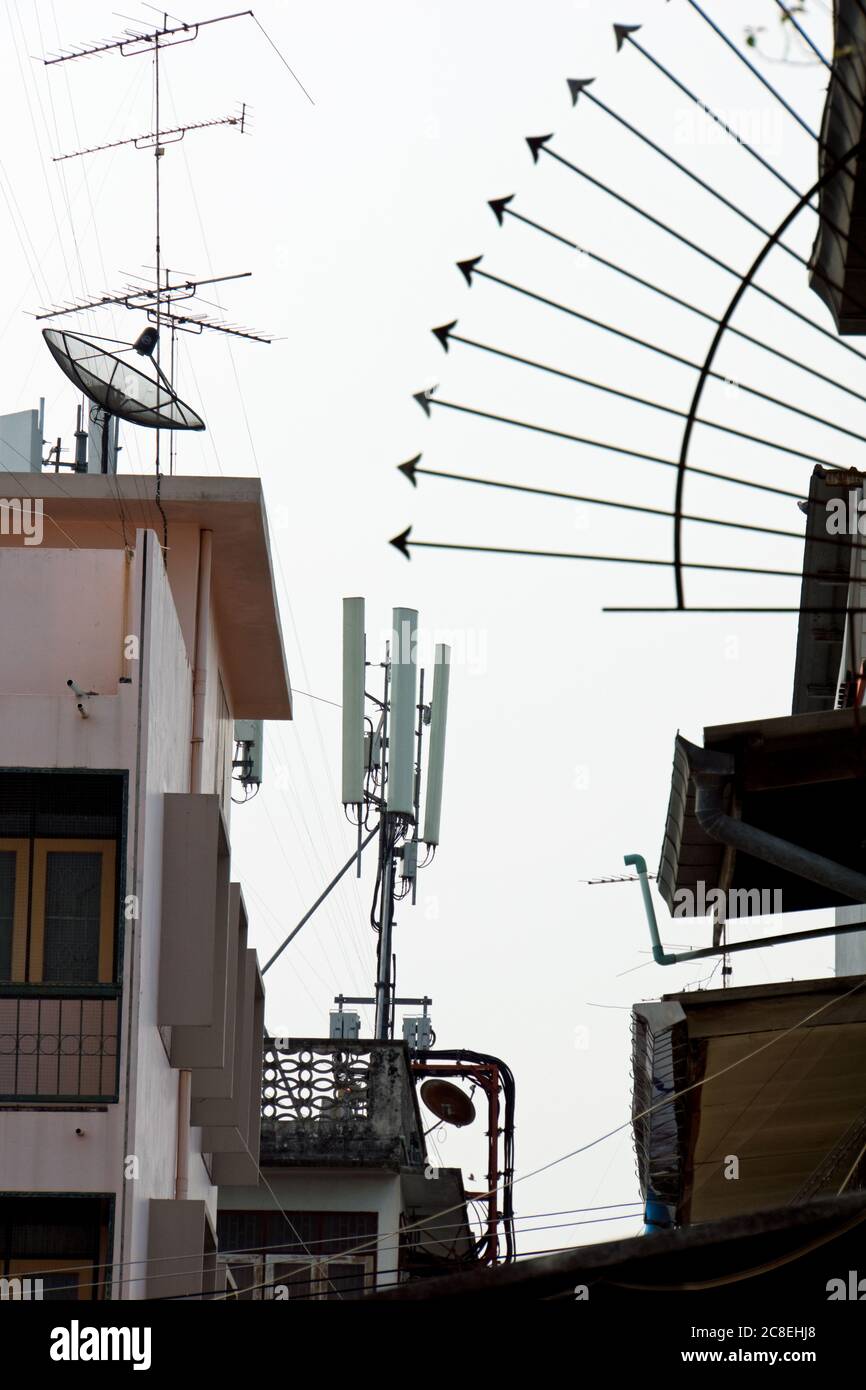 Ambiente urbano thailandese che mostra la torre di ricezione del telefono cellulare, antenne tv ed elementi di alloggiamento urbano a Bangkok, Thailandia. Foto Stock