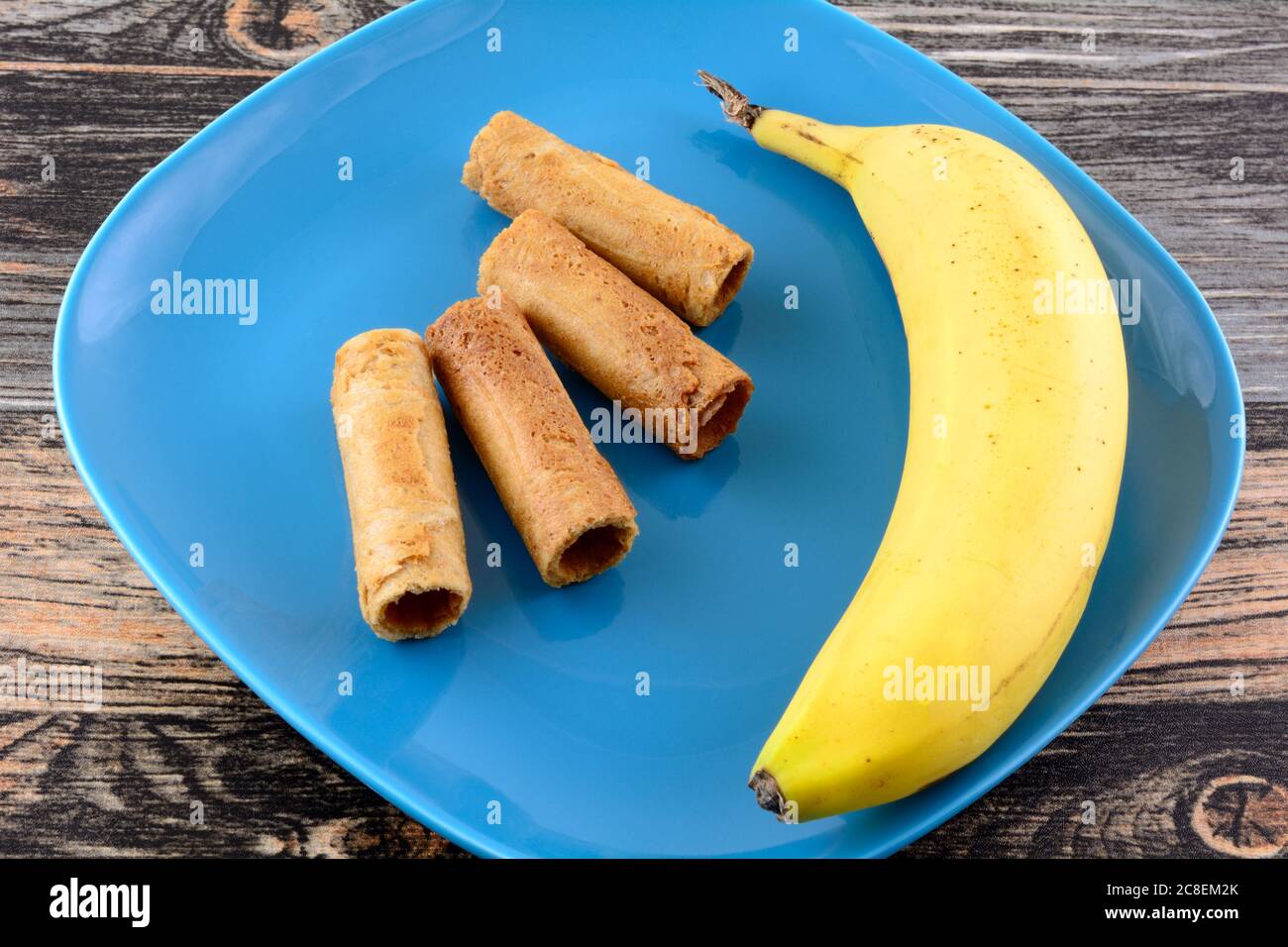 Panini di cocco thailandesi con sapore di banana e banana fresca su piatto di spuntini blu Foto Stock