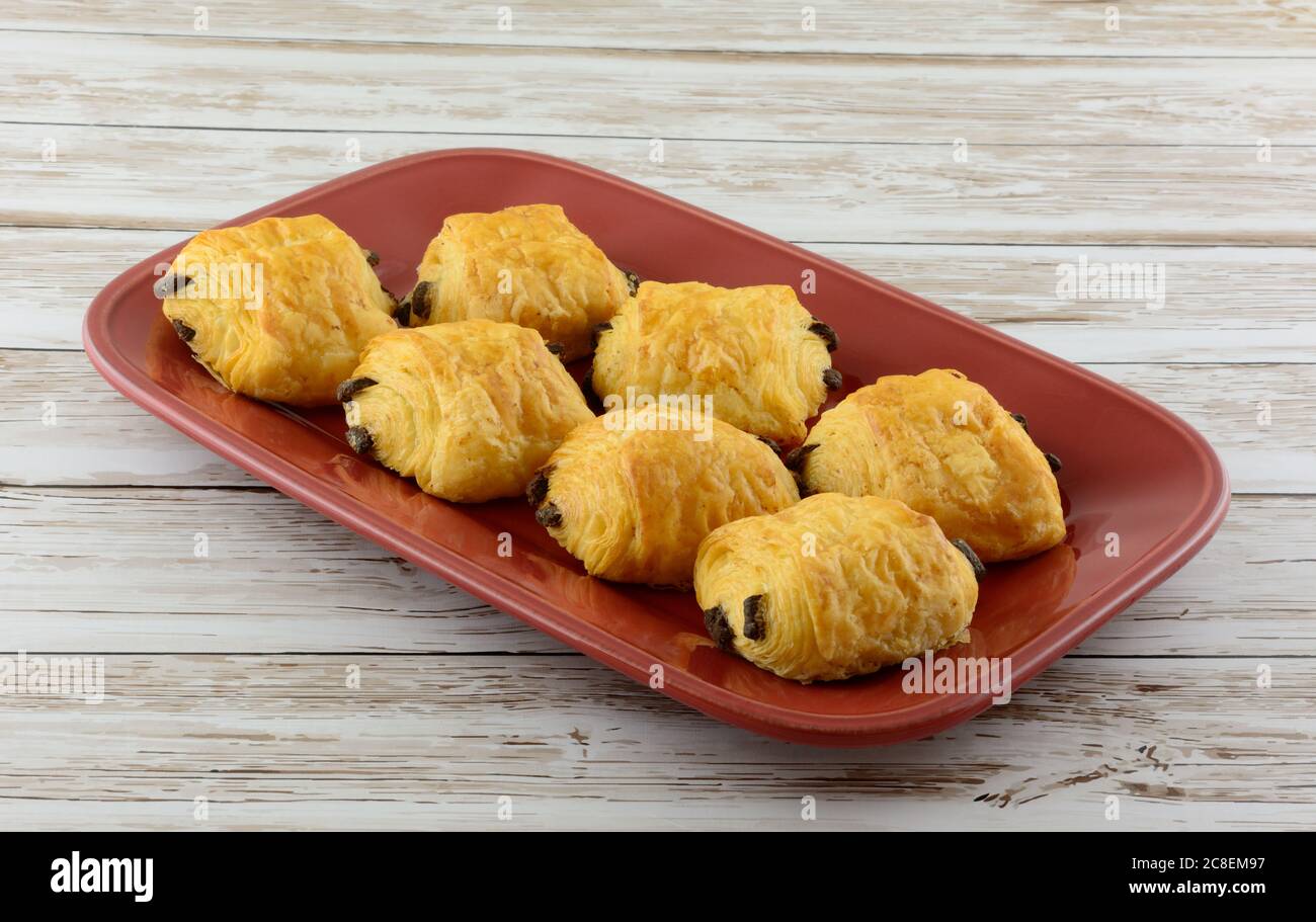Croissant al cioccolato a colazione rossa o piatto di dessert a tavola Foto Stock