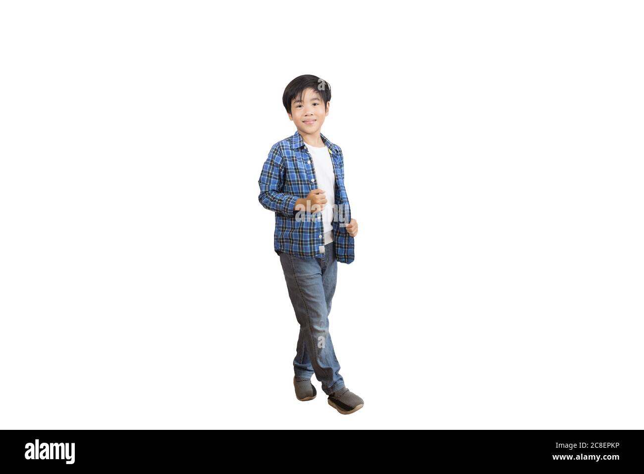 Un ritratto di un simpatico ragazzo asiatico della scuola elementare che indossa jeans e una camicia a maniche lunghe. Immagine isolata con sfondo bianco Foto Stock