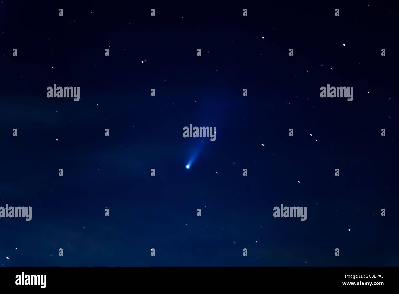 Cometa Neoswise C/2020 F3 e stelle nel cielo notturno. Astrofotografia - veduta di un meteore luminoso, fenomeno astronomico unico. Fuoco selettivo, grana Foto Stock