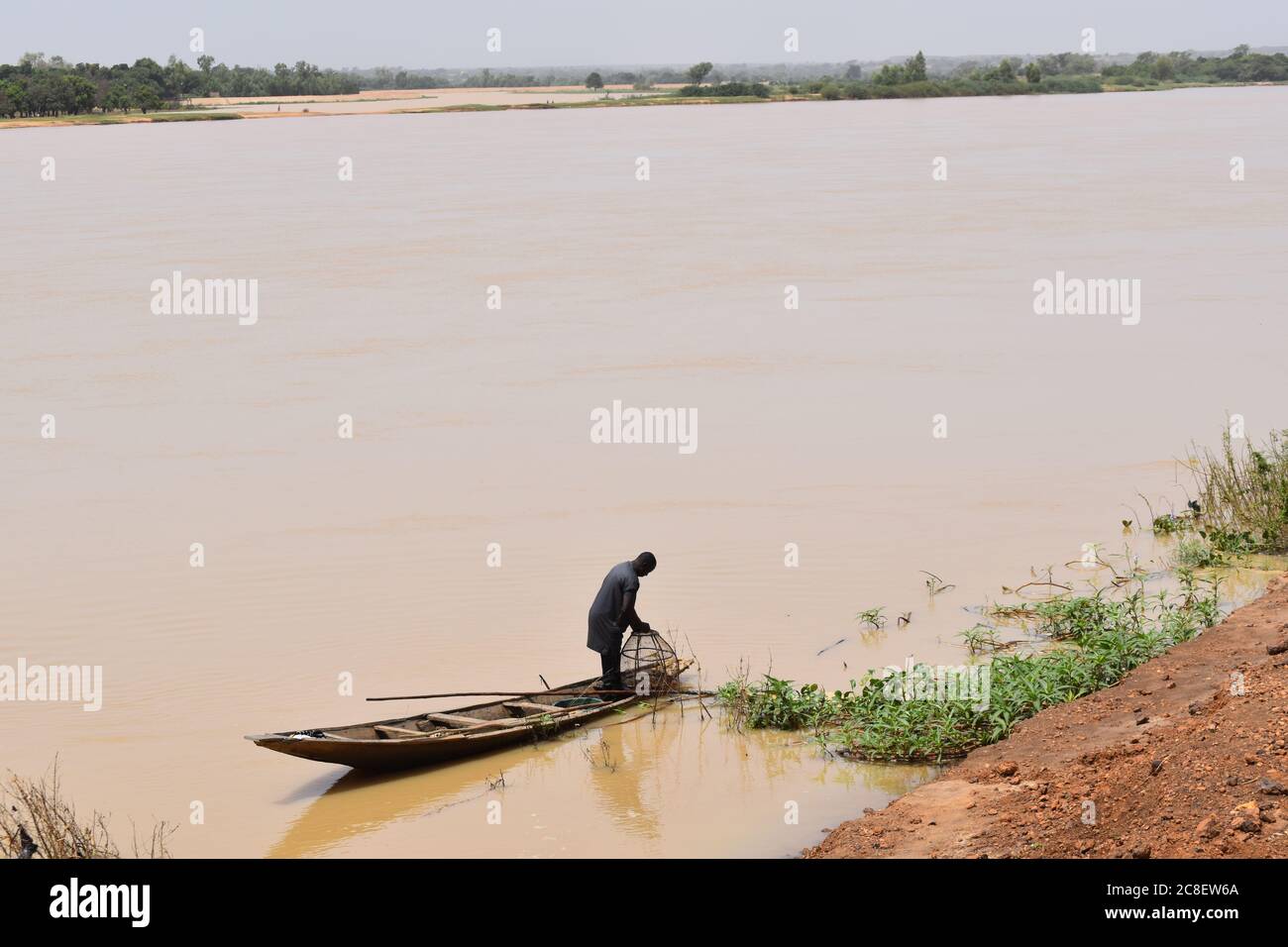 Un pescatore nella sua canoa scavata sulla riva del fiume Niger a Niamey, Niger Foto Stock