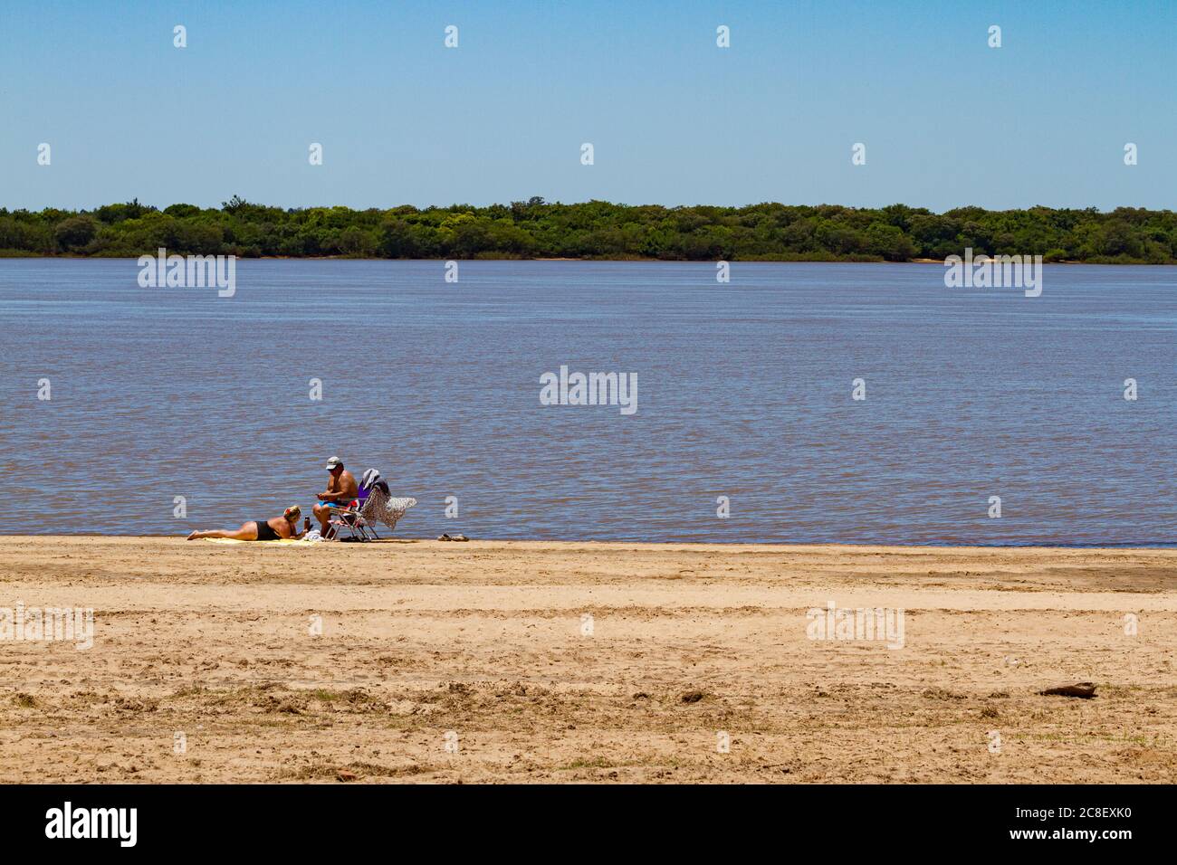 Colon - Entre Rios, ARGENTINA - CIRCA novembre 2017: Vecchia coppia prendere il sole sulla riva del fiume uruguay Foto Stock