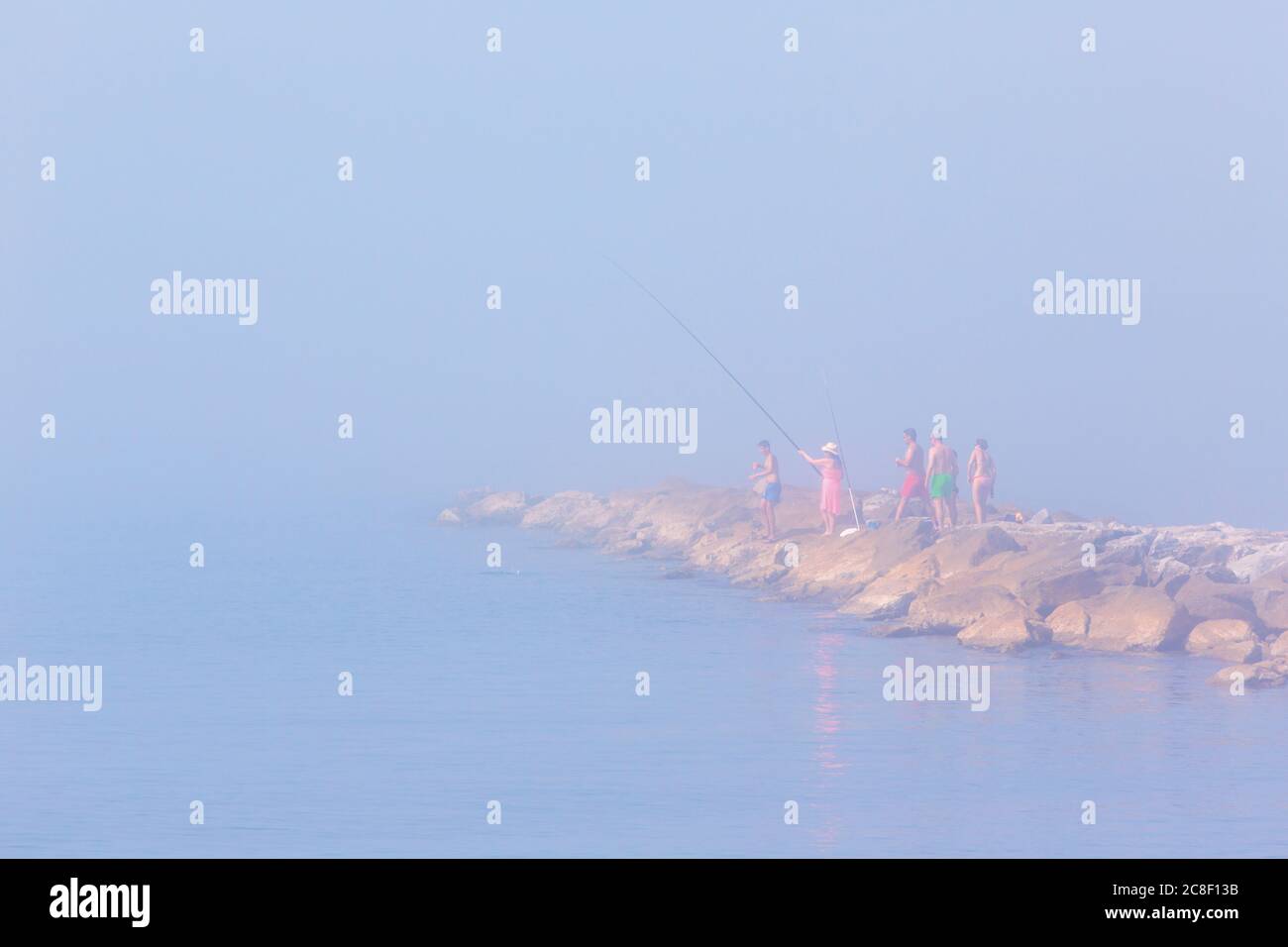 Pesca nella nebbia marina di mattina presto, Marbella, Costa del Sol, Provincia di Malaga, Spagna. Foto Stock