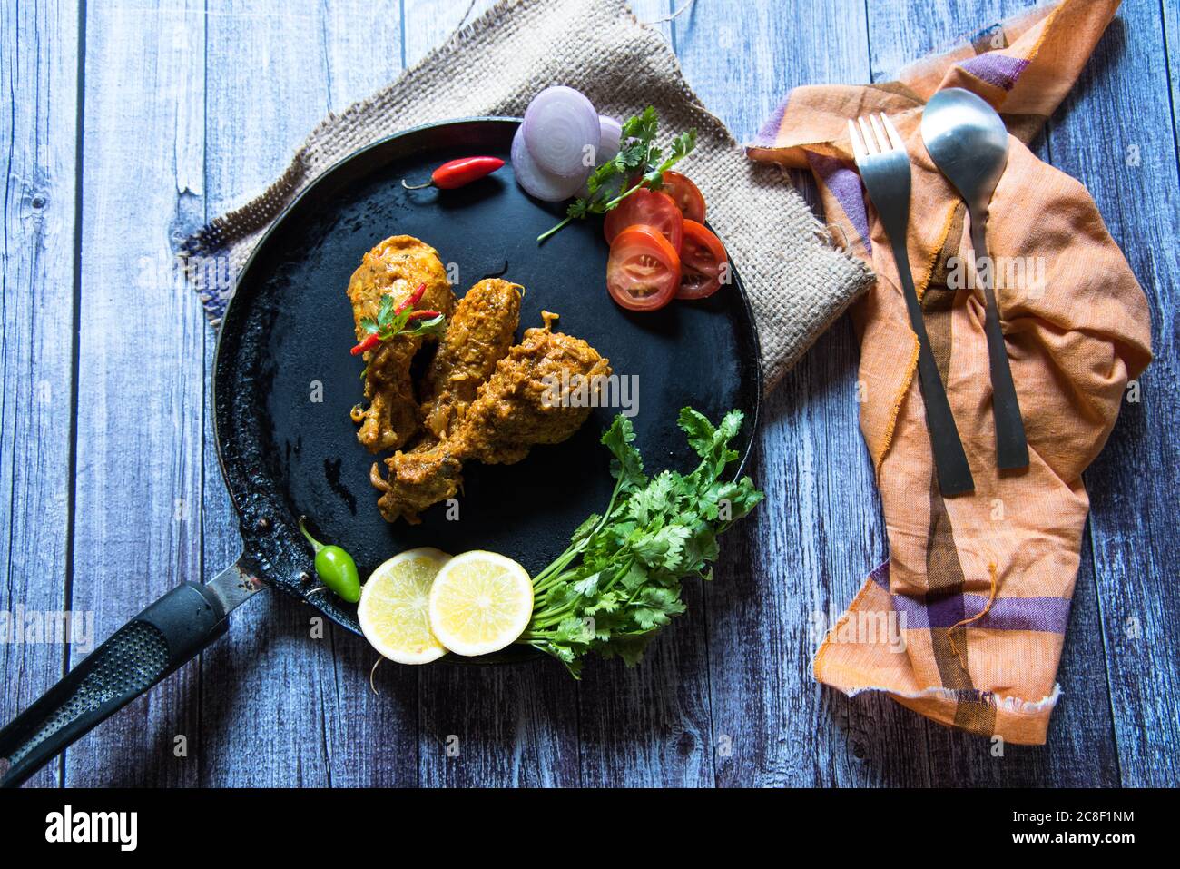 Tikka di pollo su una padella con condimenti Foto Stock