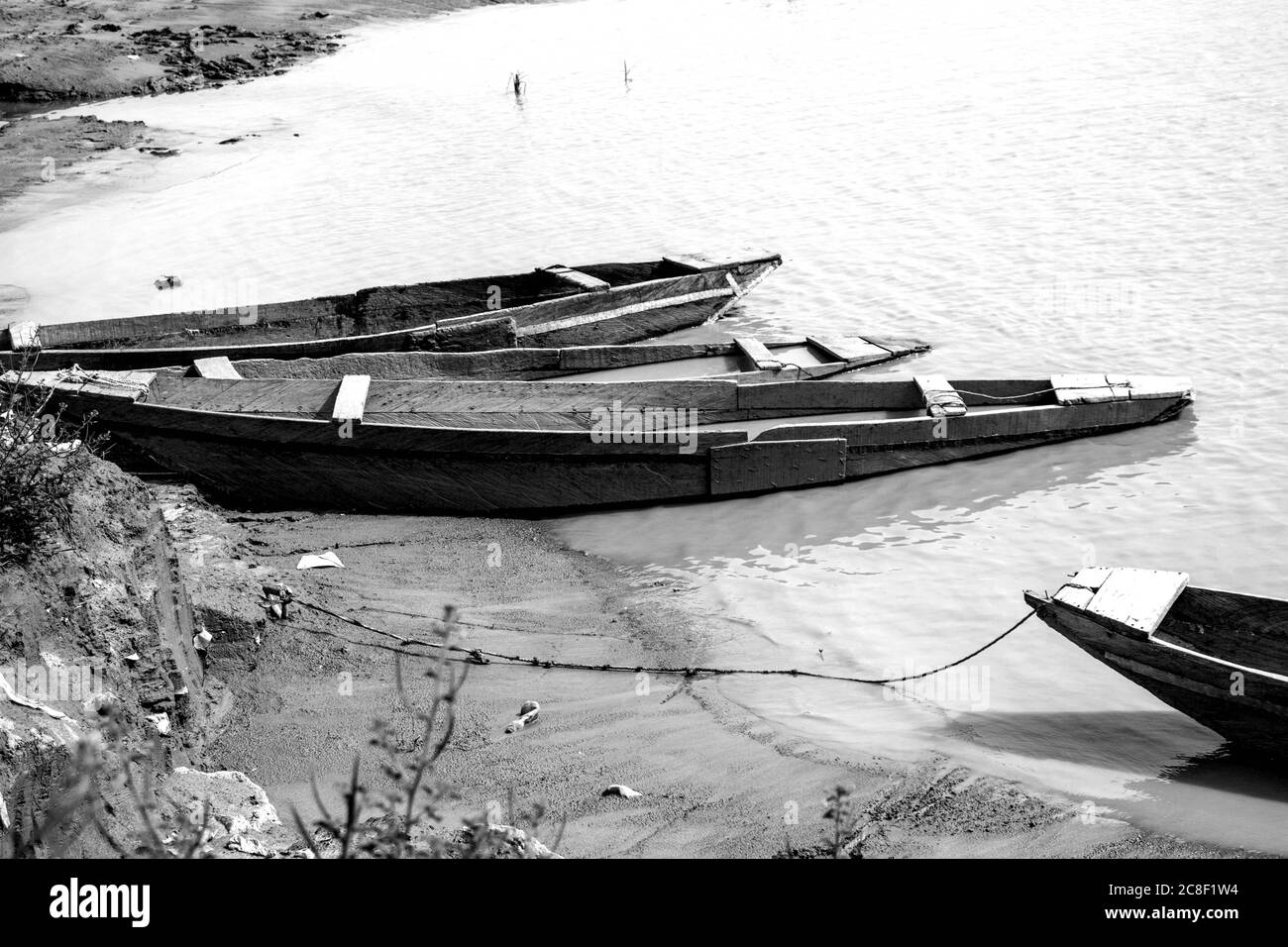 Barche di legno vicino ad un fiume. Questa immagine contiene tre vecchie barche di legno attraccate vicino ad una riva del fiume. Foto Stock