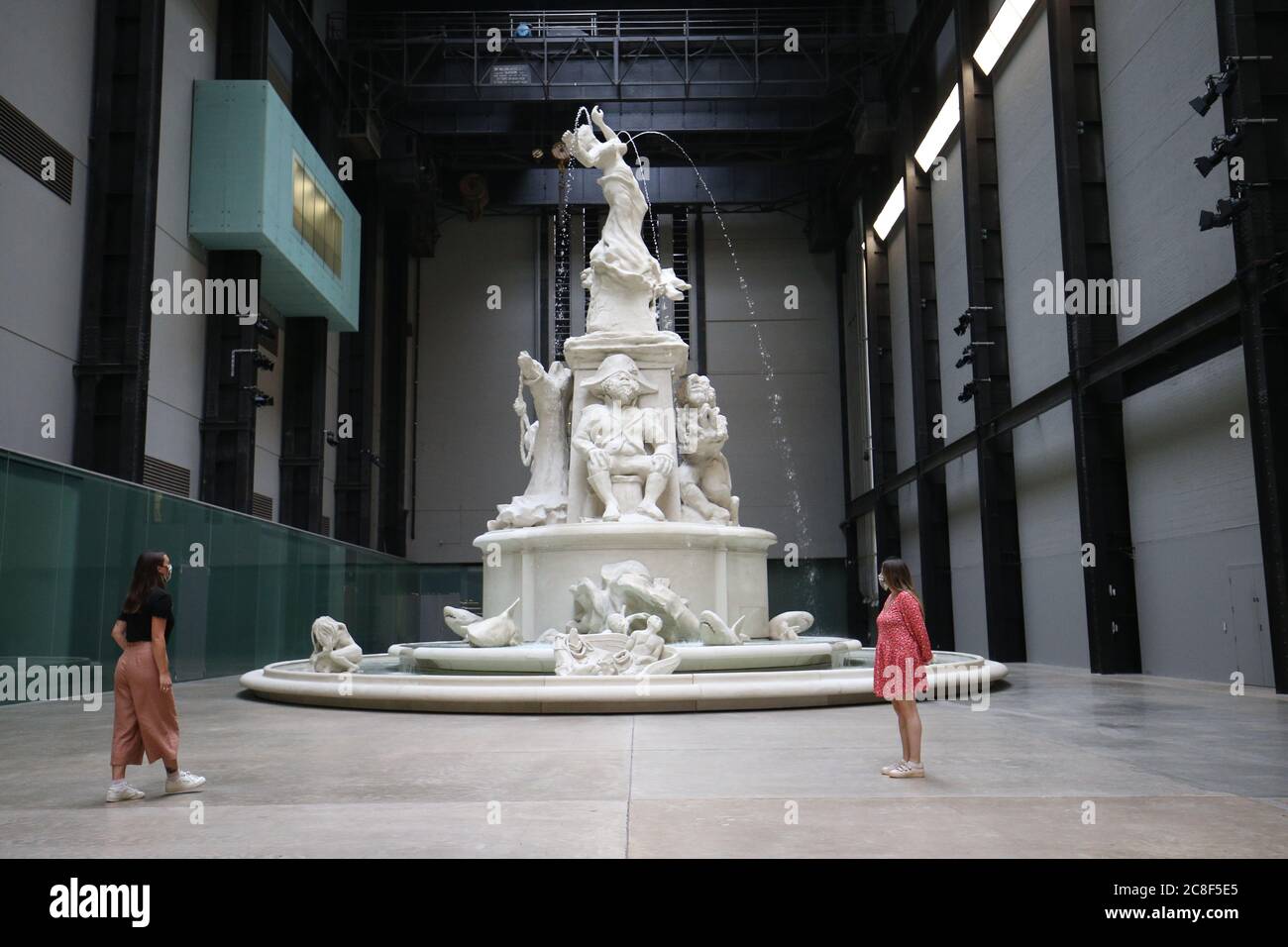 I membri del personale si mettono in posa davanti all'installazione di Kara Walker 'Fons Americanus' nella Sala turbine al Tate Modern mentre la galleria si prepara a riaprire al pubblico lunedì 27 luglio dopo il blocco del coronavirus. Foto Stock