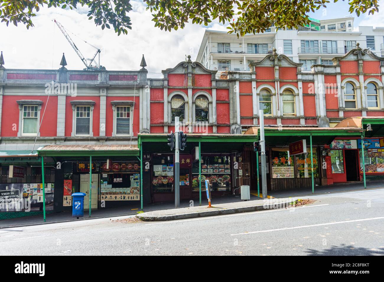 Fila di negozi di mattoni rossi su Queen Street, Auckland, Foto Stock
