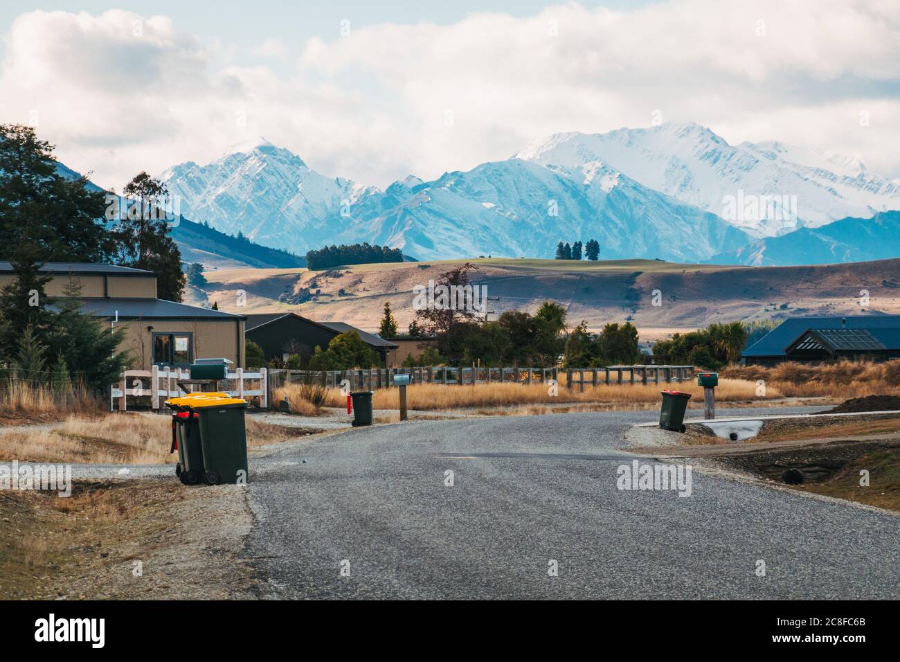 Bin su una strada residenziale in Albert Town, un fiorente sviluppo vicino a Wanaka, Nuova Zelanda. Le Alpi meridionali si possono vedere dietro Foto Stock Bin su una strada residenziale in Albert Town, un fiorente sviluppo vicino a Wanaka, Nuova Zelanda. Le Alpi meridionali si possono vedere dietro Foto Stock
