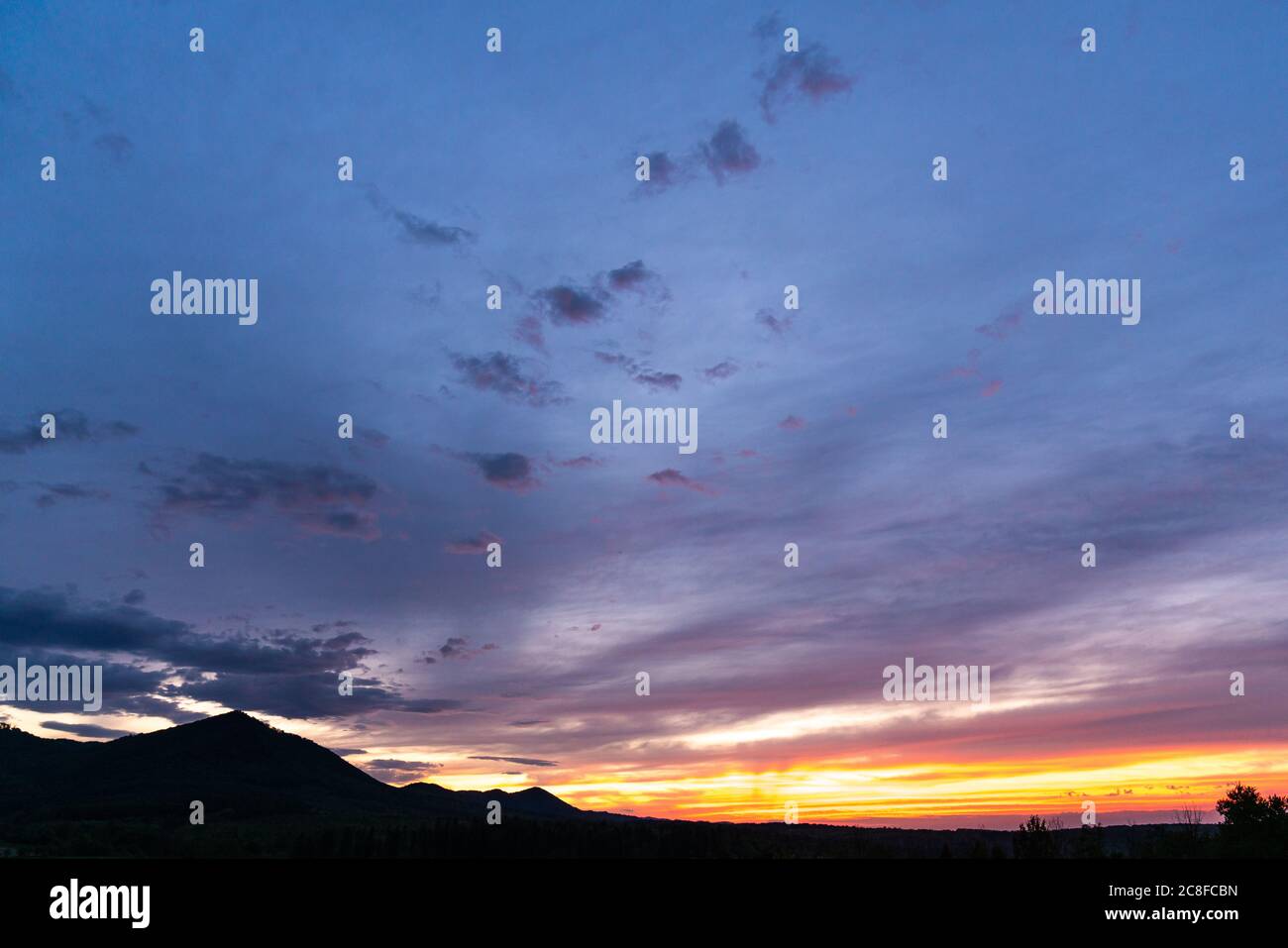 Panorama colorato magnifico tramonto in campagna sopra colline e campi Foto Stock