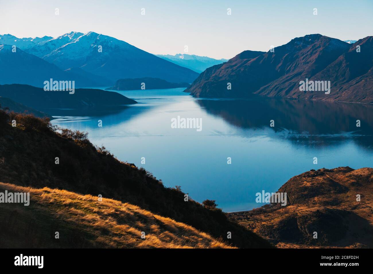 Le montagne si riflettono sulla superficie di un lago incredibilmente fermo Wanaka, in una giornata limpida e tranquilla nell'Isola del Sud della Nuova Zelanda Foto Stock