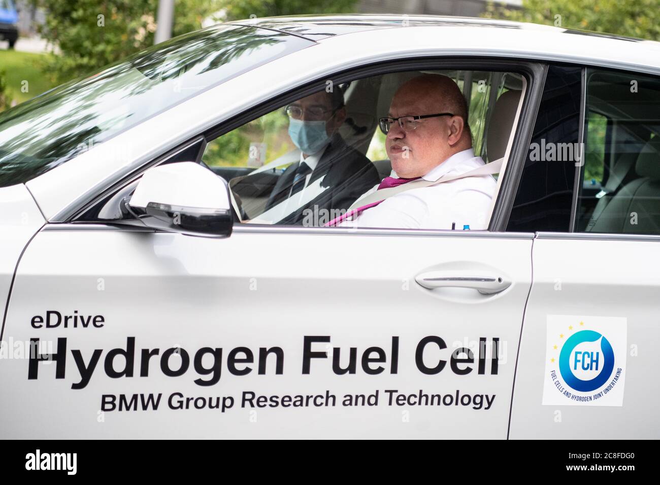 Garching, Germania. 24 luglio 2020. Peter Altmaier (CDU), Ministro federale dell'economia, è al volante di un veicolo alimentato a idrogeno durante una visita ad un centro di ricerca del costruttore di automobili BMW. Altmaier visita il centro di ricerca per informarsi sullo stato di sviluppo della tecnologia delle celle a combustibile a idrogeno. Credit: Attualità dal vivo di Matthias Balk/dpa/Alamy Foto Stock