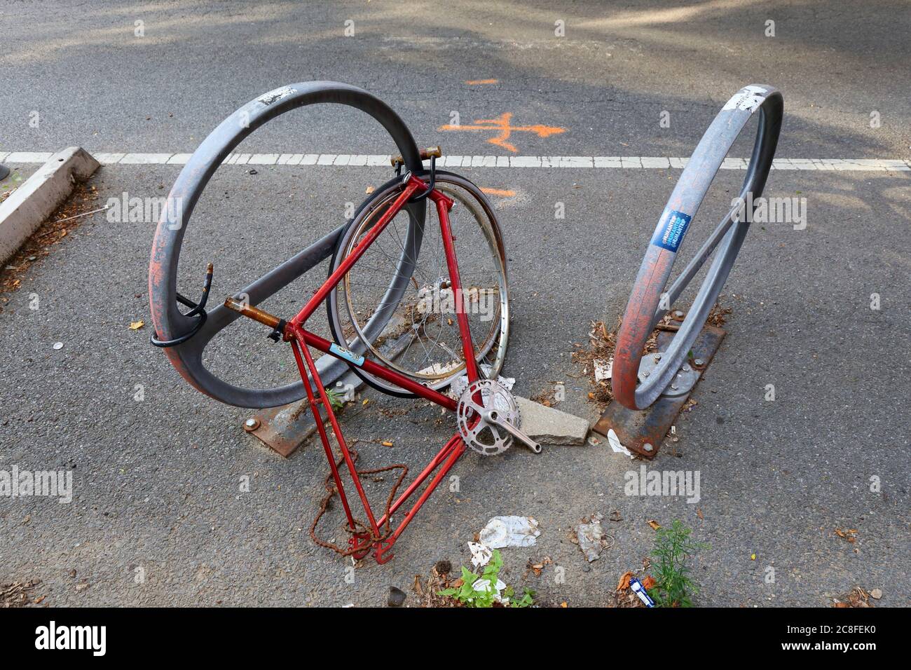 Una bicicletta spogliata e abbandonata attaccata a un portabiciclette di New York. Foto Stock