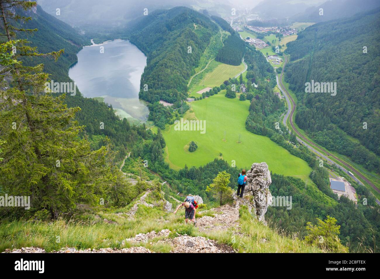 Gli escursionisti godono di una fantastica vista panoramica sul paesaggio alpino con Leopoldsteiner See e Eisenerz in condizioni di pioggia in estate. Foto Stock