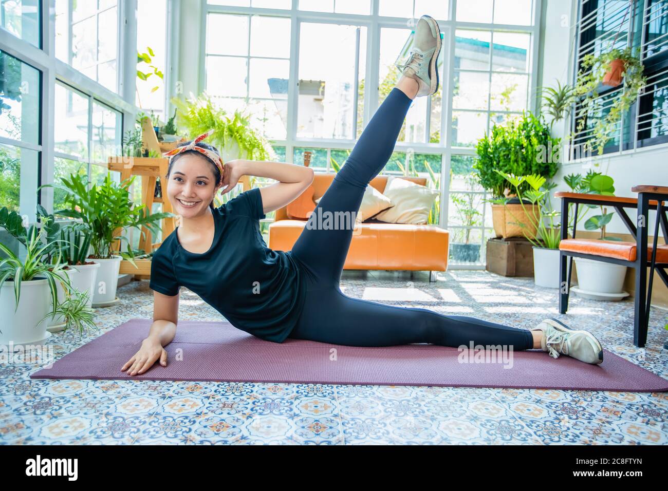 Sorriso felice bella giovane donna asiatica stretching esercizio di allenamento a casa, fitness sport ragazza aerobica e sano concetto. Foto Stock
