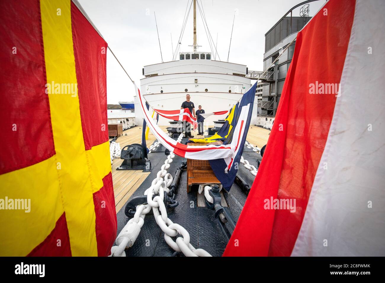 Rab McAulay (a sinistra) e Tony Smith, del team di manutenzione, alzano le bandiere di abbigliamento sul Royal Yacht Britannia per segnare la riapertura dell'attrazione turistica di Edimburgo ai membri del pubblico lunedì 27 luglio. Foto Stock