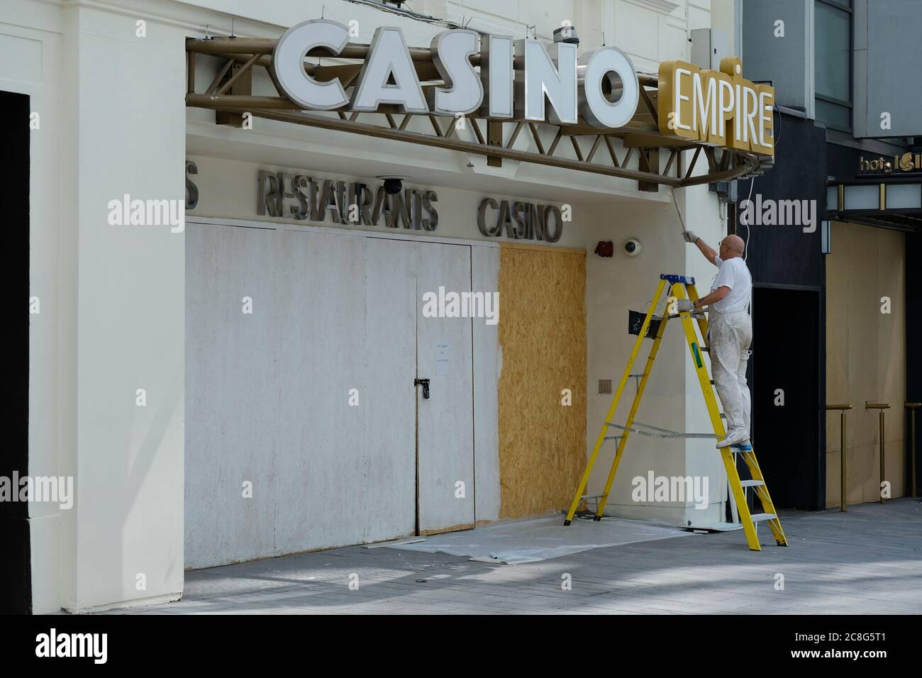 Un operaio dipinge su calze all'Empire Casino in Leicester Square. La maggior parte delle aziende rimane chiusa dopo il rilassamento delle restrizioni del coronavirus. Foto Stock