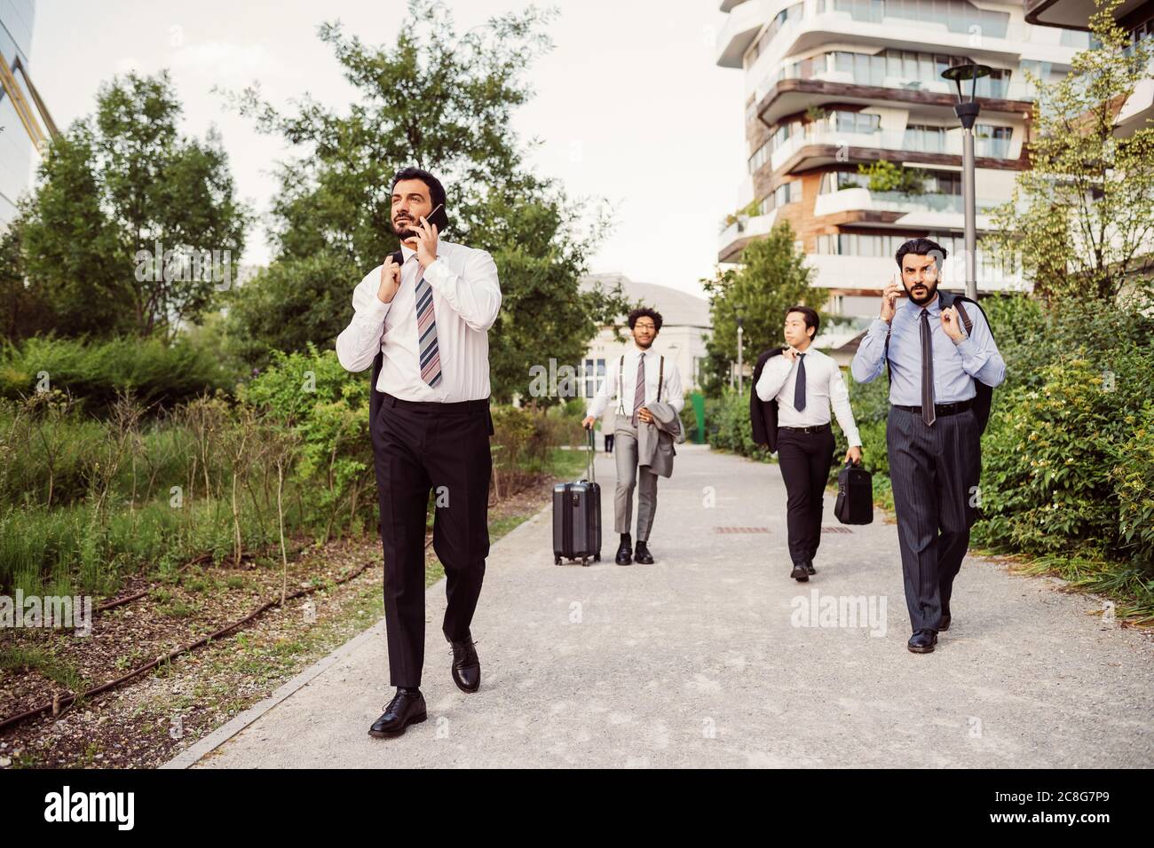 Gruppo misto di uomini d'affari appesi insieme in città. Foto Stock