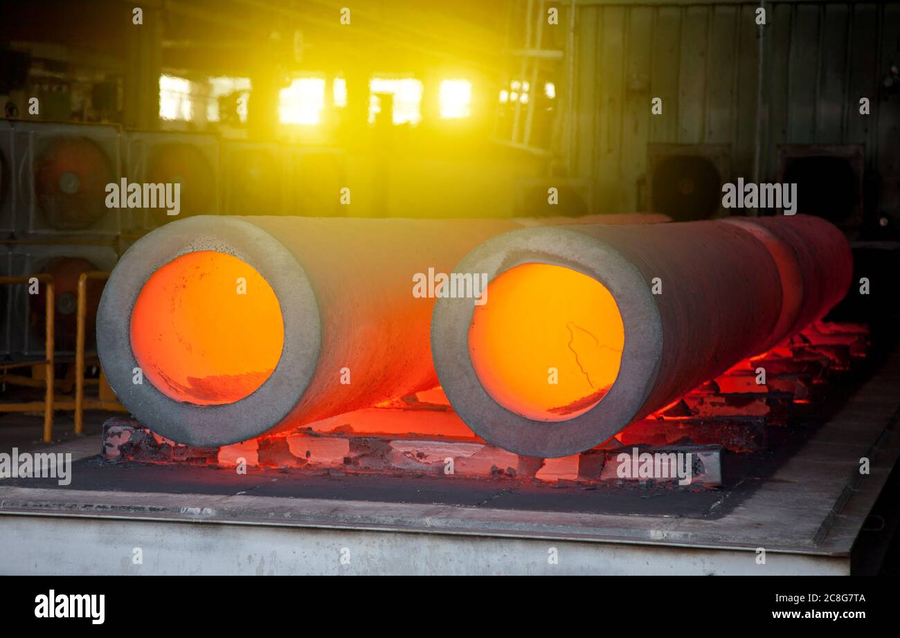 Primo piano di tubi caldi incandescenti in una fabbrica di acciaio. Foto Stock