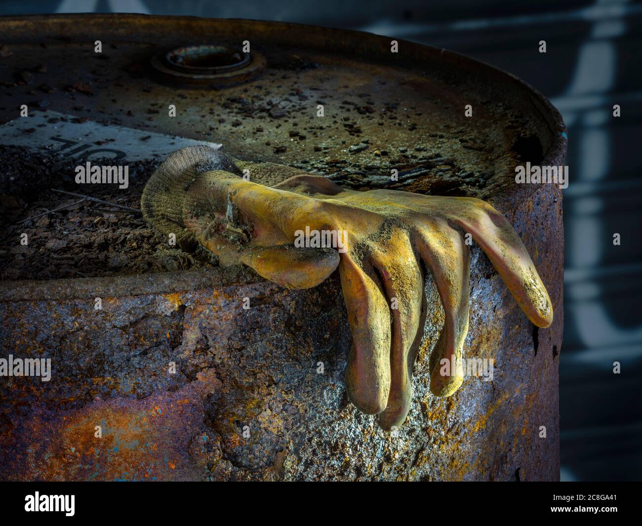 Guanto da lavoro in gomma marcio su tamburo di olio in decadimento arrugginito in un edificio industriale abbandonato, Conshohocken, Pennsylvania, USA Foto Stock