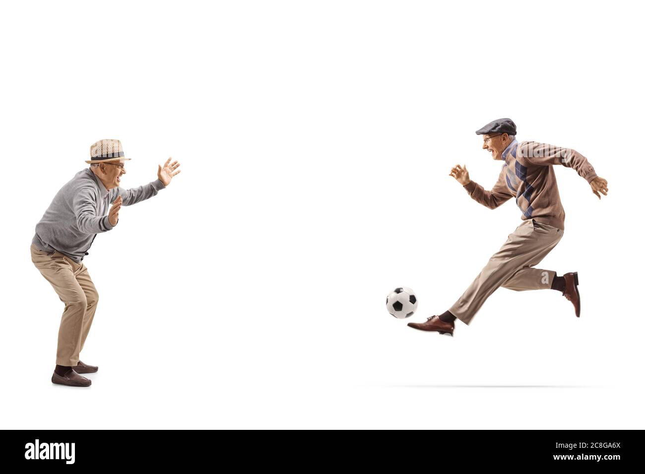 Due nonni che giocano a calcio isolati su sfondo bianco Foto Stock