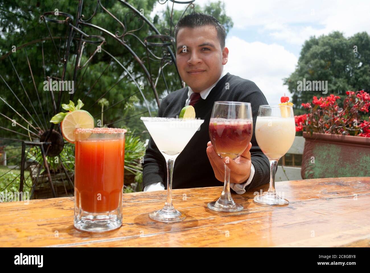Mani uomo e donna che fanno toast con bevande alcoliche all'aperto, bevande preparate da bar Tender in Guatemala. Foto Stock
