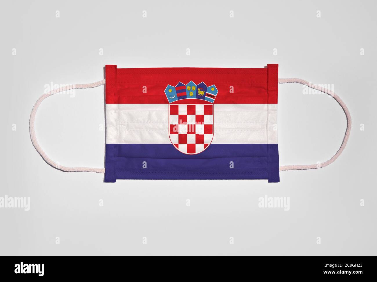 Immagine simbolica crisi corona, maschera facciale, maschera respiratoria, protezione bocca e naso con bandiera della Croazia, sfondo bianco Foto Stock