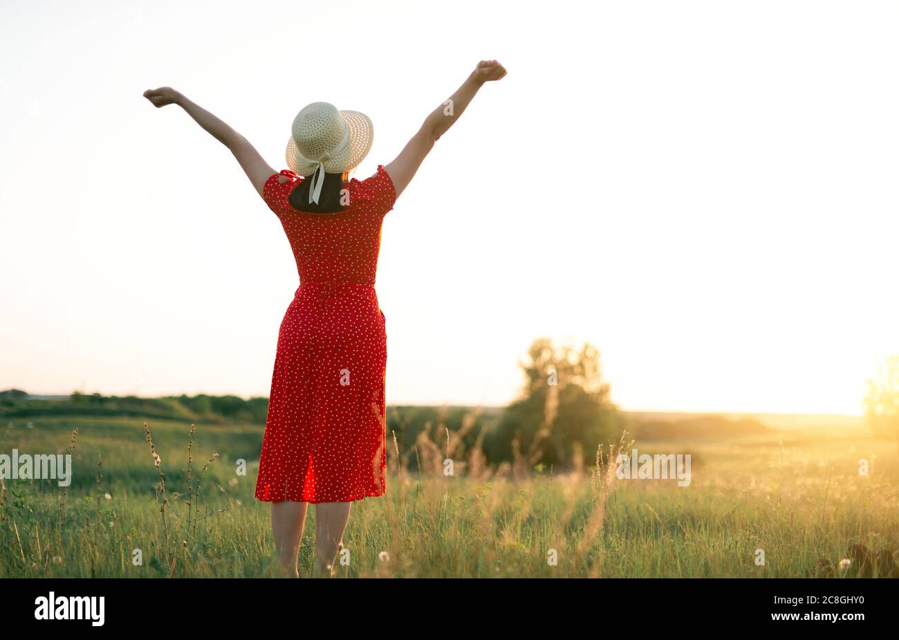 respirare, donna con mani sollevate godendo il sole sul campo Foto Stock