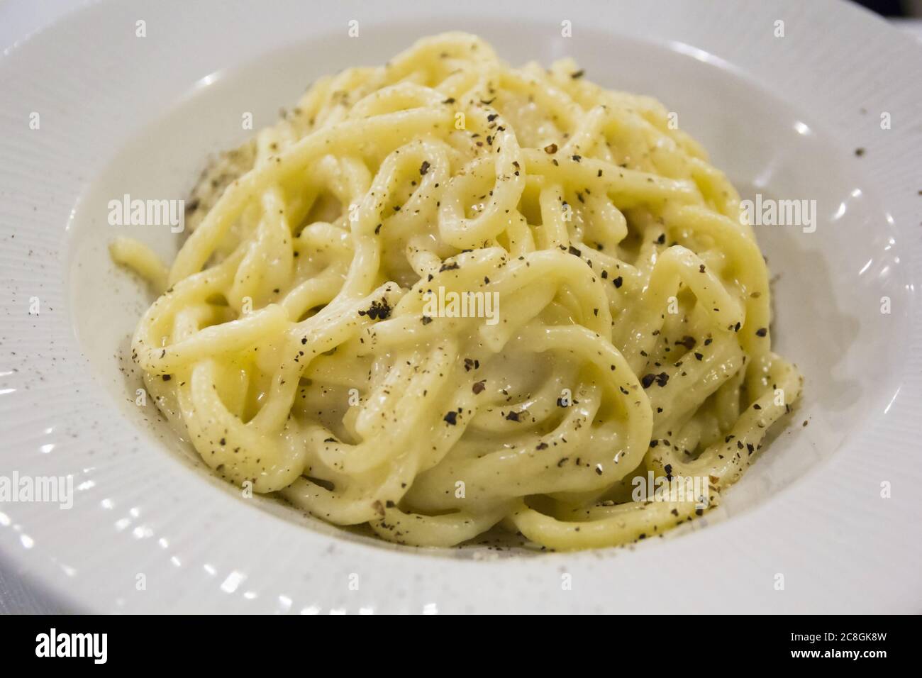 Spaghetti al formaggio (cacio) e pepe, piatto tradizionale romano. Cucina italiana Foto Stock