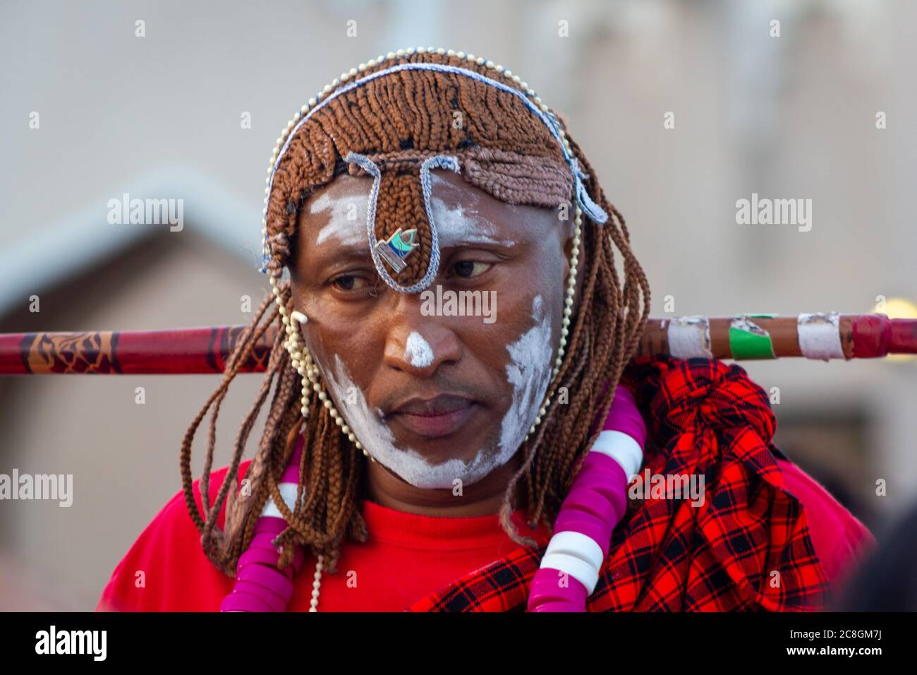 Ritratto di uomo africano che indossa costume tradizionale tribù con sfondo sfocato girato durante il festival africano nel villaggio culturale di Katara Doha Foto Stock
