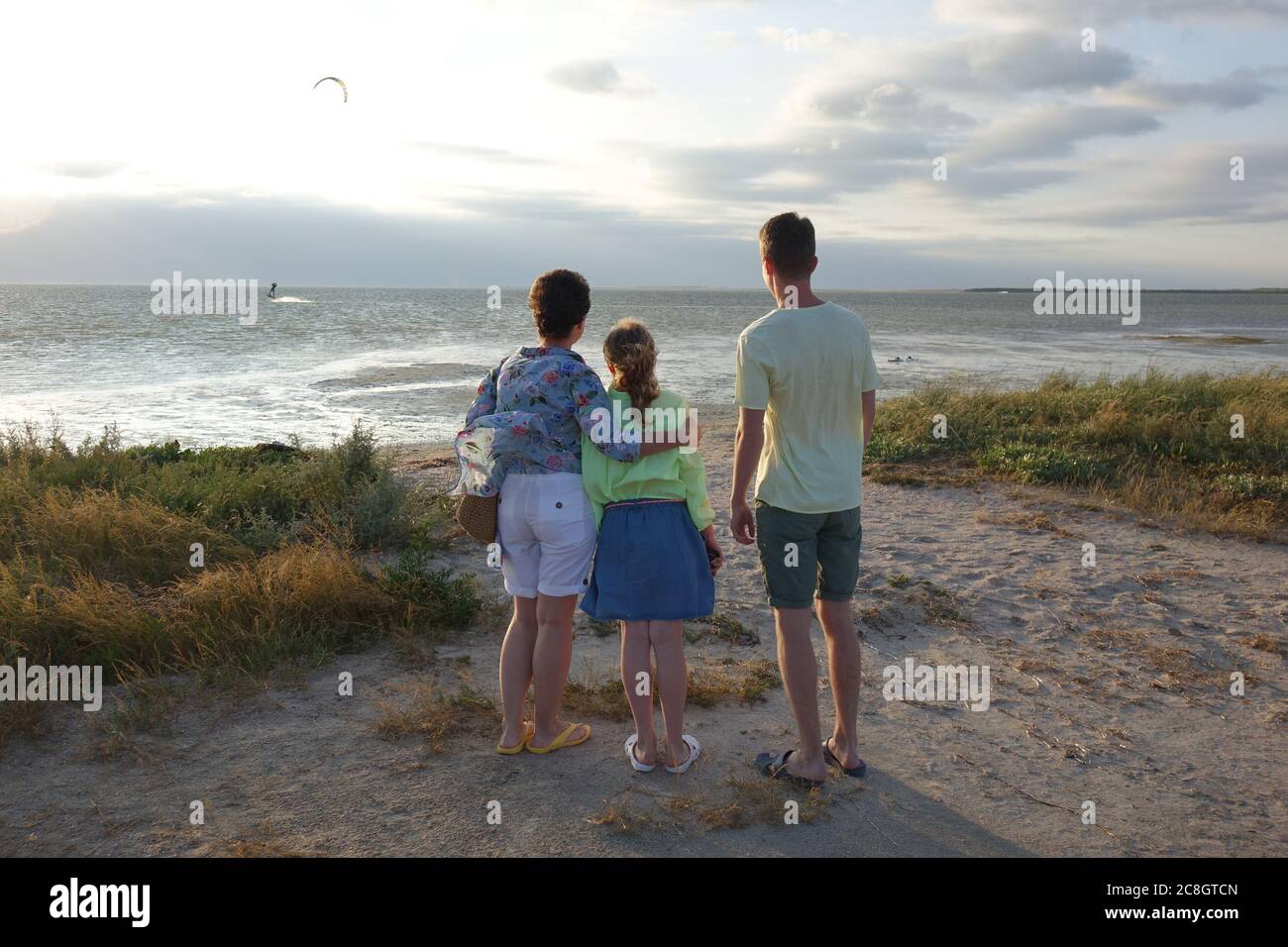 famiglia sulla spiaggia guardando il tramonto Foto Stock