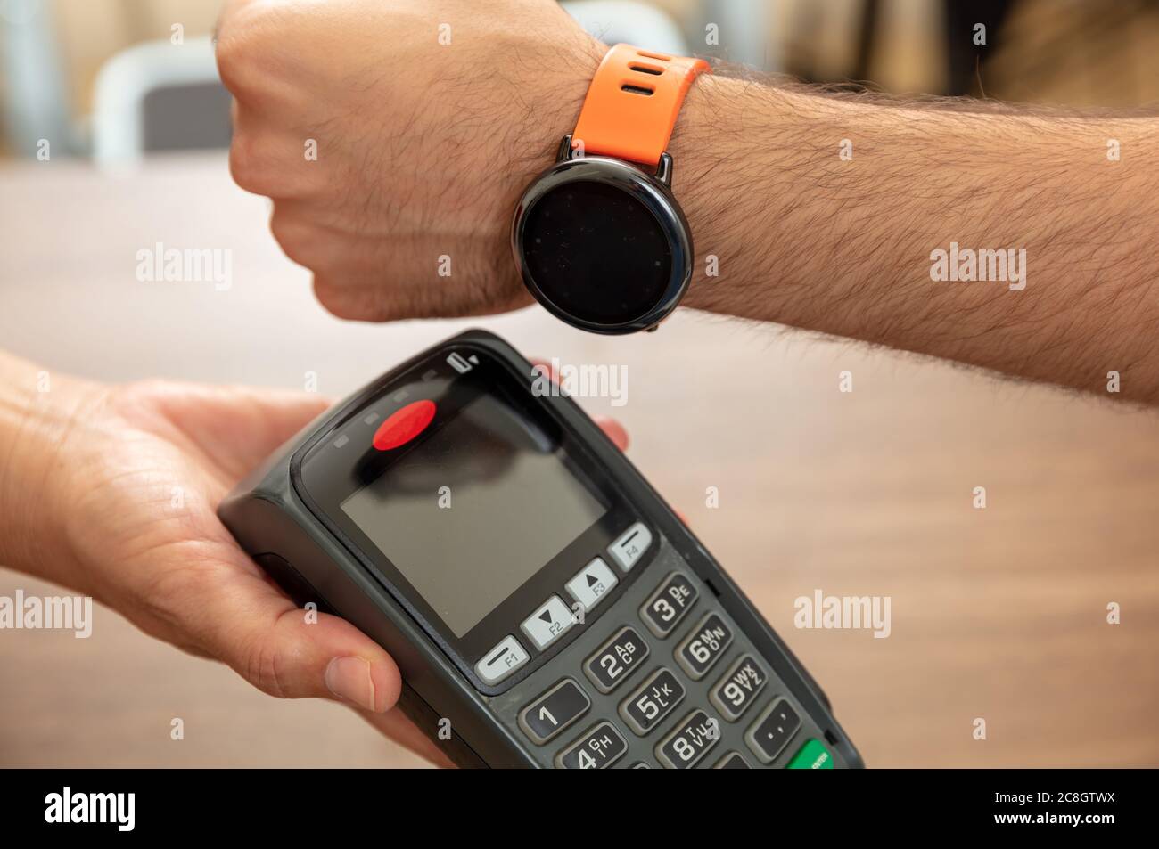 Pagamento mobile, orologio intelligente nfc, tecnologia wireless Near Field Communication. Cassa e cliente mani con POS macchina e Smart Watch, closeup vi Foto Stock