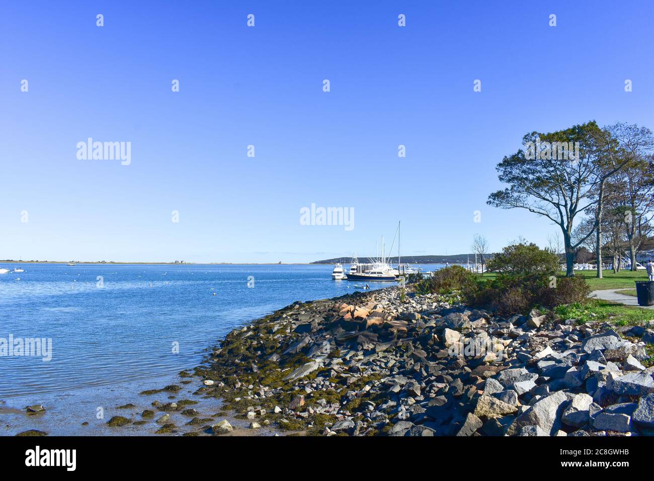 Plymouth, ma USA porto con barche e molo; percorso attraverso il parco con parete di roccia fino all'acqua Foto Stock