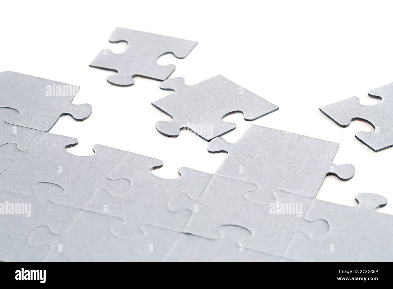 Pezzi di puzzle incompleti su sfondo bianco. Foto Stock