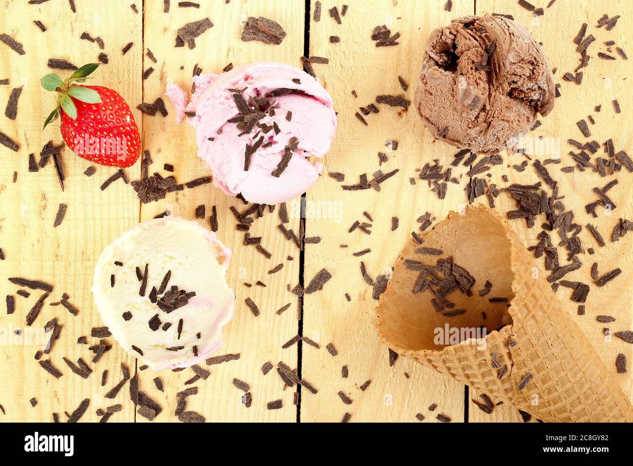 palle di gelato e cono su superficie di legno Foto Stock