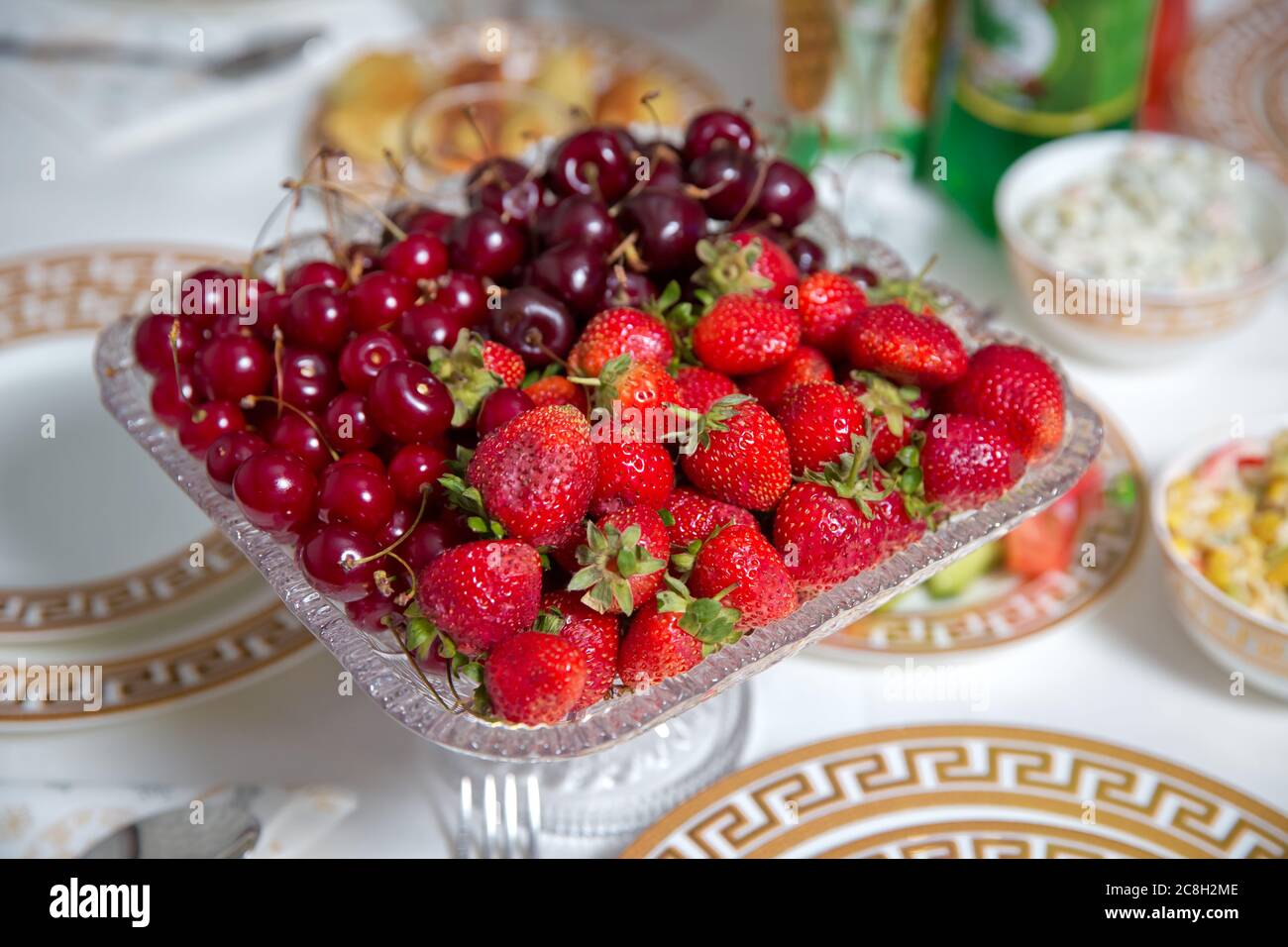 Frutta fresca d'estate: Ciliegie, fragole biologiche ciotola di cristallo . Fragole e ciliegie in una ciotola di cristallo. Foto Stock