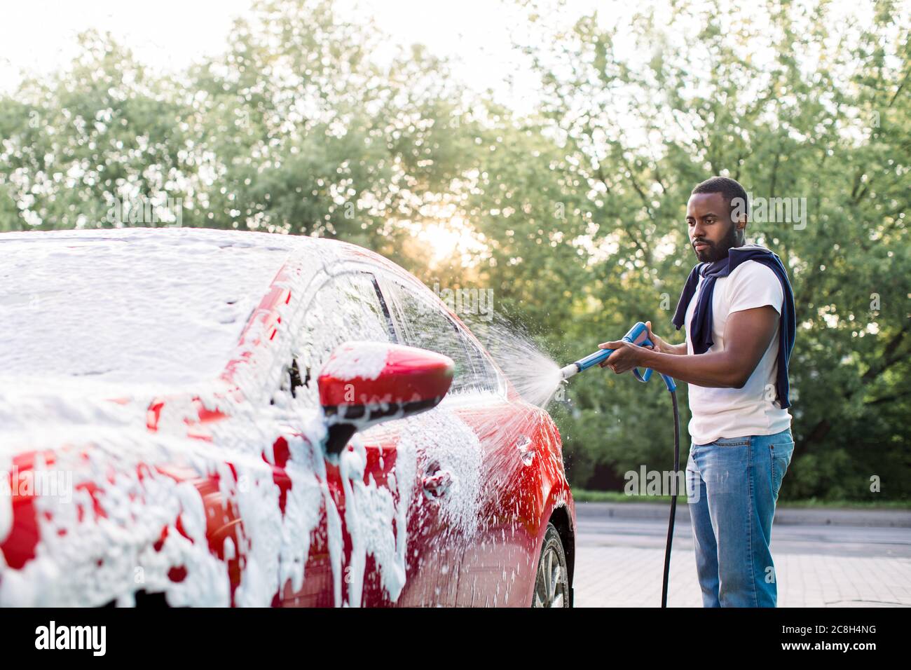 auto in schiuma rosa al lavaggio auto, donna si lava felicemente la sua auto  Foto stock - Alamy